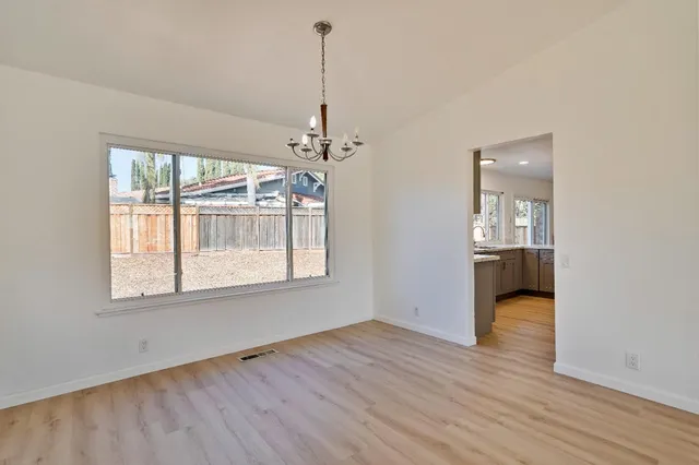 a view of empty room with wooden floor and ceiling fan