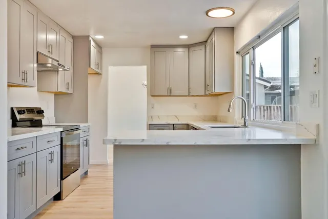 a kitchen with stainless steel appliances a sink stove and cabinets