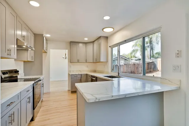 a kitchen with a sink cabinets appliances and a large window