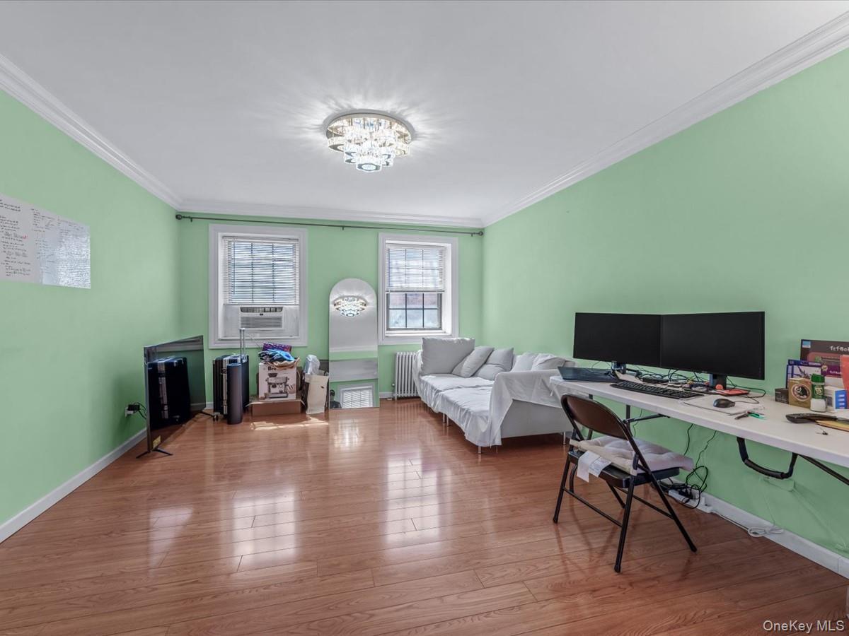 147-11 79th Avenue, Unit 1N Queens, NY 11367 - Photo 3 of 8 Office area with crown molding, wood finished floors, and radiator