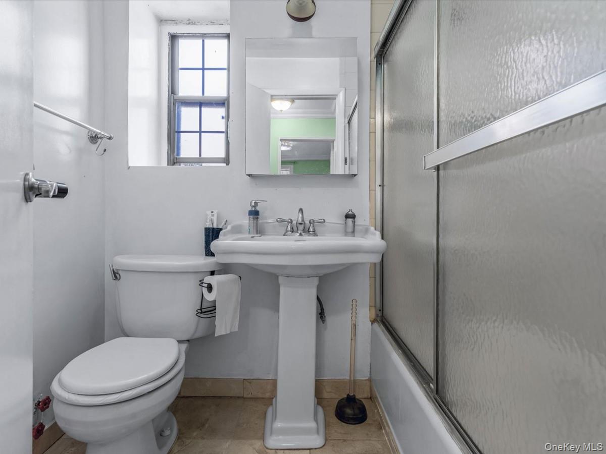 147-11 79th Avenue, Unit 1N Queens, NY 11367 - Photo 7 of 8 Full bath featuring bath / shower combo with glass door and light tile patterned floors