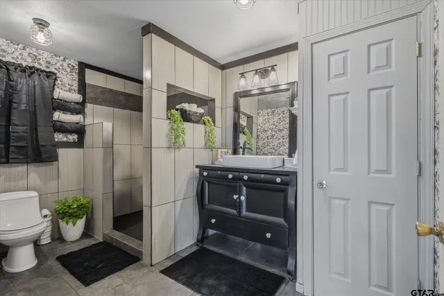 a bathroom with a sink a toilet and shower