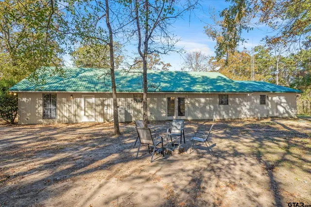 a view of a yard with table and chairs under an umbrella