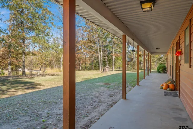 a view of a porch with furniture and floor to ceiling window