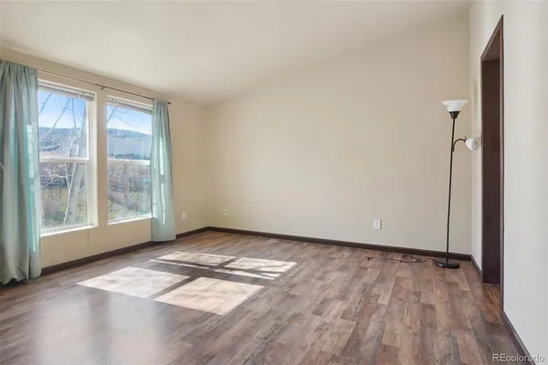a view of a hallway with wooden floor and windows