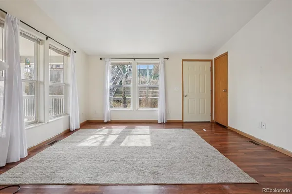 a kitchen with stainless steel appliances granite countertop a stove top oven a refrigerator a sink and dishwasher with wooden floor