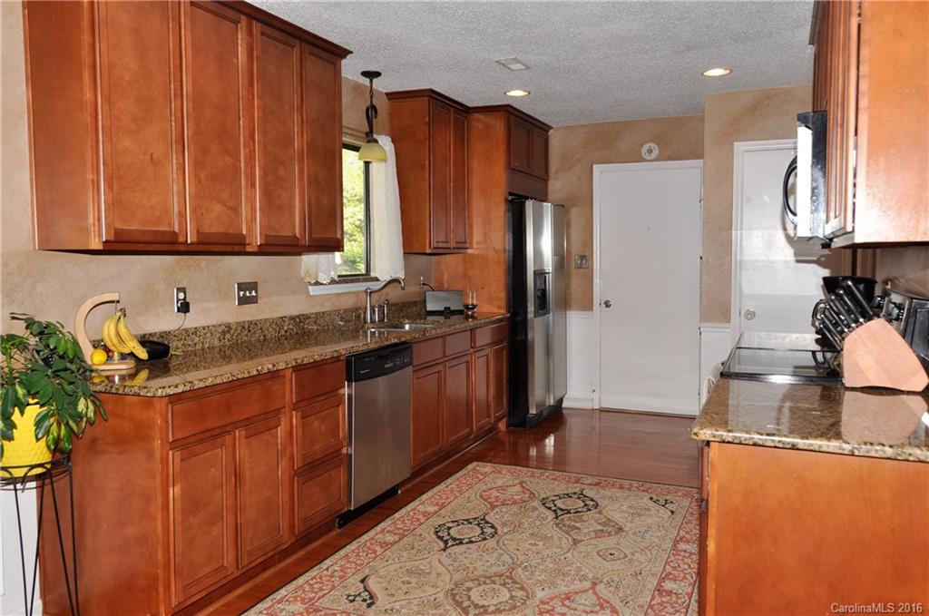 9924 Fairway Ridge Road Charlotte, NC 28277 - Photo 4 of 21 a kitchen with stainless steel appliances granite countertop wooden cabinets a sink a stove a refrigerator and with wooden cabinets