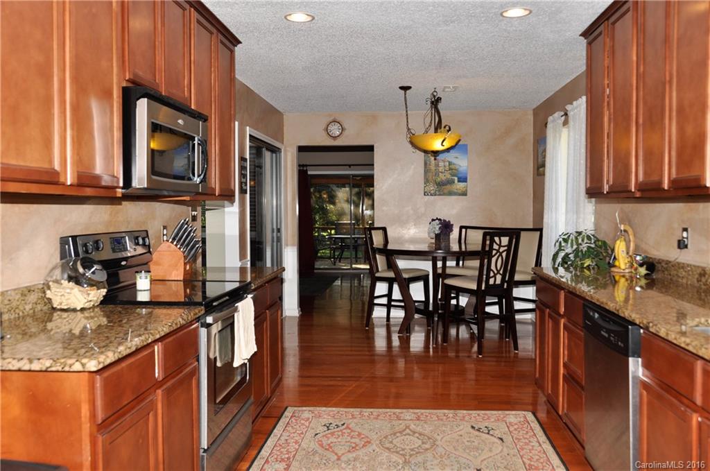 9924 Fairway Ridge Road Charlotte, NC 28277 - Photo 6 of 21 a kitchen with stainless steel appliances granite countertop a stove a sink and a dining table