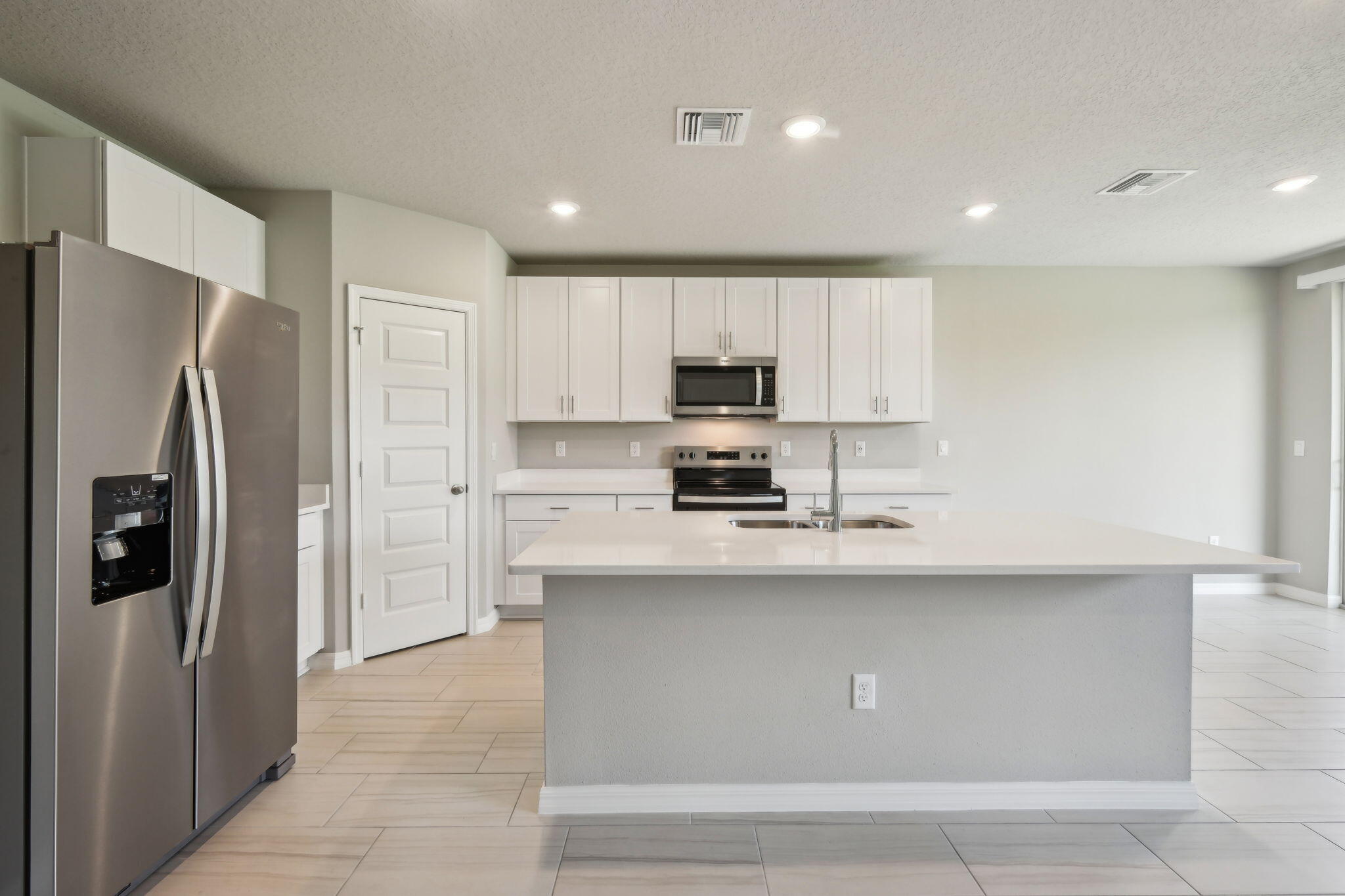 5413 Hampton Park Circle Vero Beach, FL 32966 - Photo 11 of 39 a kitchen with stainless steel appliances a refrigerator sink and stove