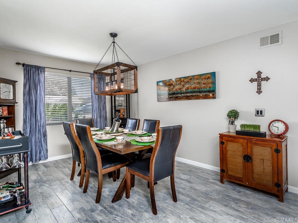 1286 Via Pavion Santa Maria, CA 93455 - Photo 11 of 38 a dining room with furniture potted plants and wooden floor