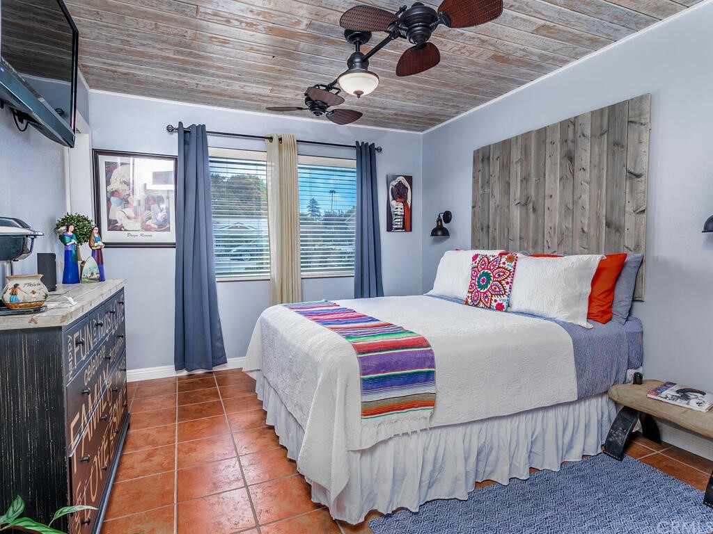 1286 Via Pavion Santa Maria, CA 93455 - Photo 17 of 38 a bedroom with a large bed and a chandelier