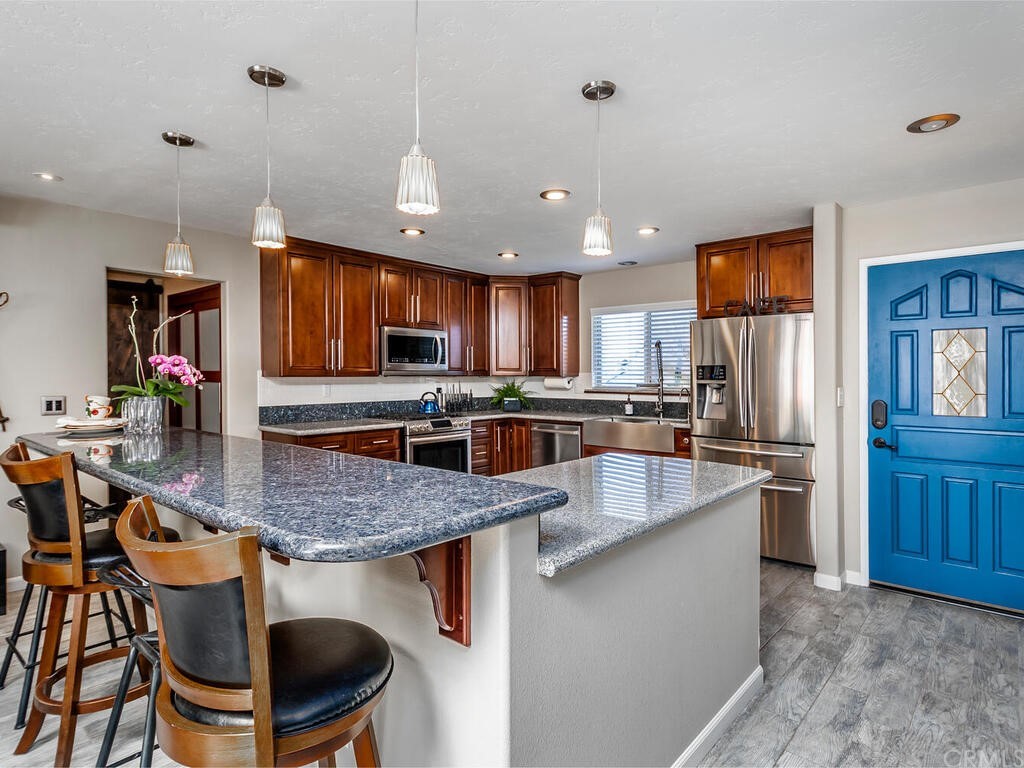 1286 Via Pavion Santa Maria, CA 93455 - Photo 5 of 38 a kitchen with stainless steel appliances granite countertop a stove top oven a sink a dining table and chairs