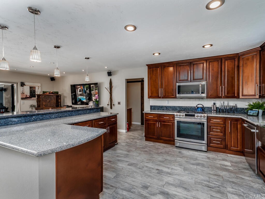 1286 Via Pavion Santa Maria, CA 93455 - Photo 8 of 38 a kitchen with stainless steel appliances granite countertop a stove a sink dishwasher a refrigerator and a oven with wooden floor