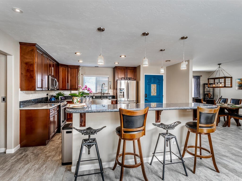 1286 Via Pavion Santa Maria, CA 93455 - Photo 10 of 38 a kitchen with stainless steel appliances kitchen island granite countertop a sink and cabinets