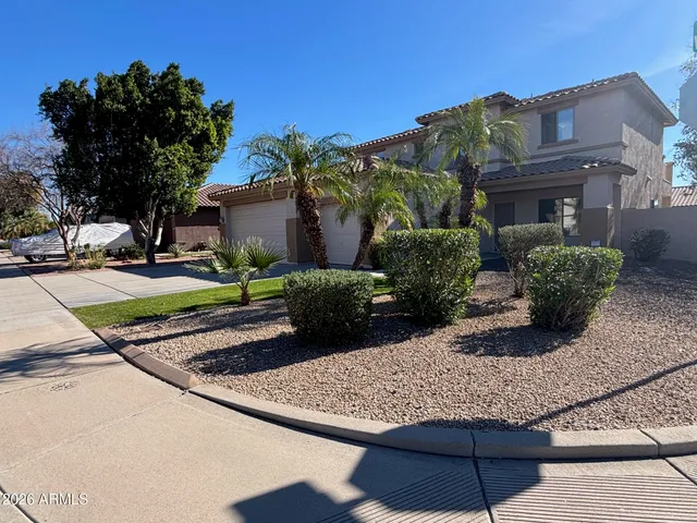 a view of a house with a yard and potted plants