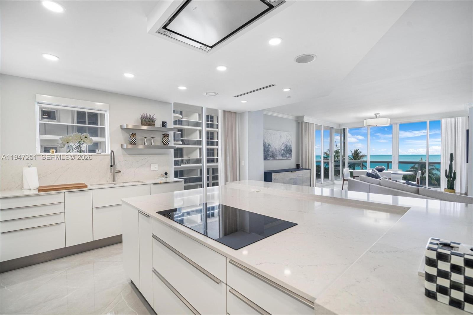a large white kitchen with a large window appliances and cabinets