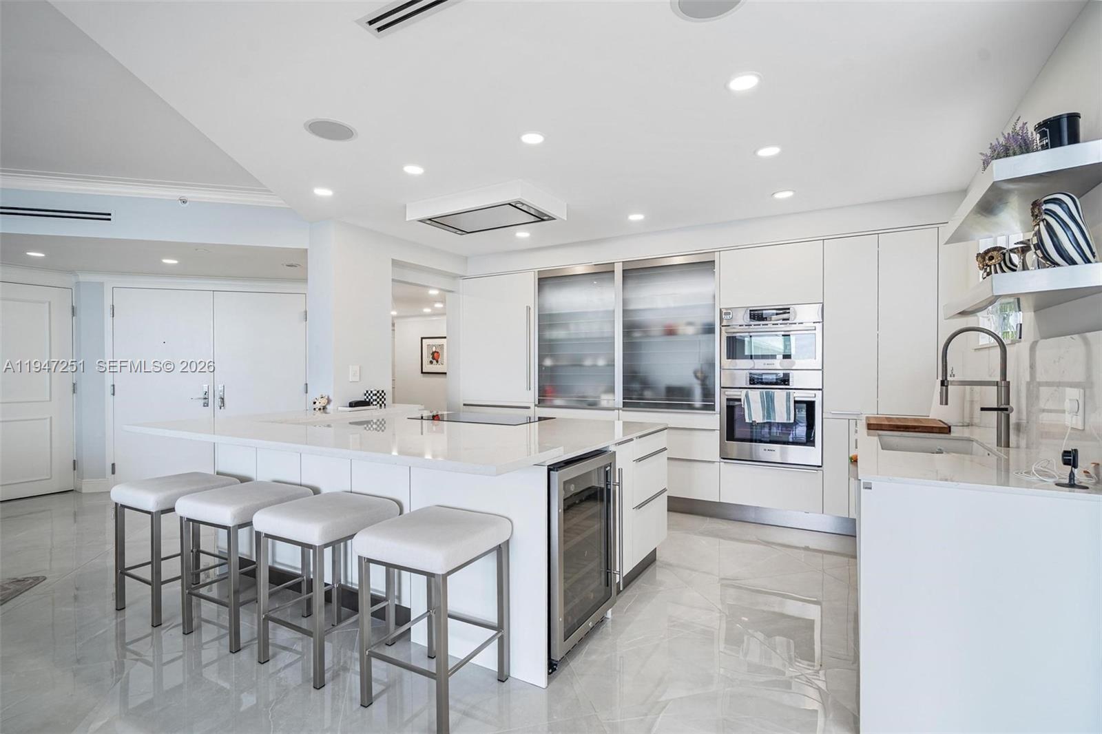 9559 Collins Avenue, Unit S4E Surfside, FL 33154 - Photo 11 of 37 a kitchen with stainless steel appliances kitchen island granite countertop a sink and cabinets