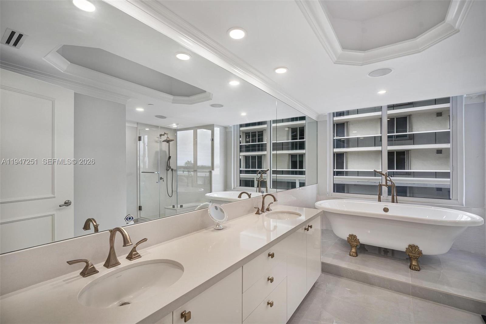 9559 Collins Avenue, Unit S4E Surfside, FL 33154 - Photo 18 of 37 a bathroom with a double vanity sink a mirror and a bathtub