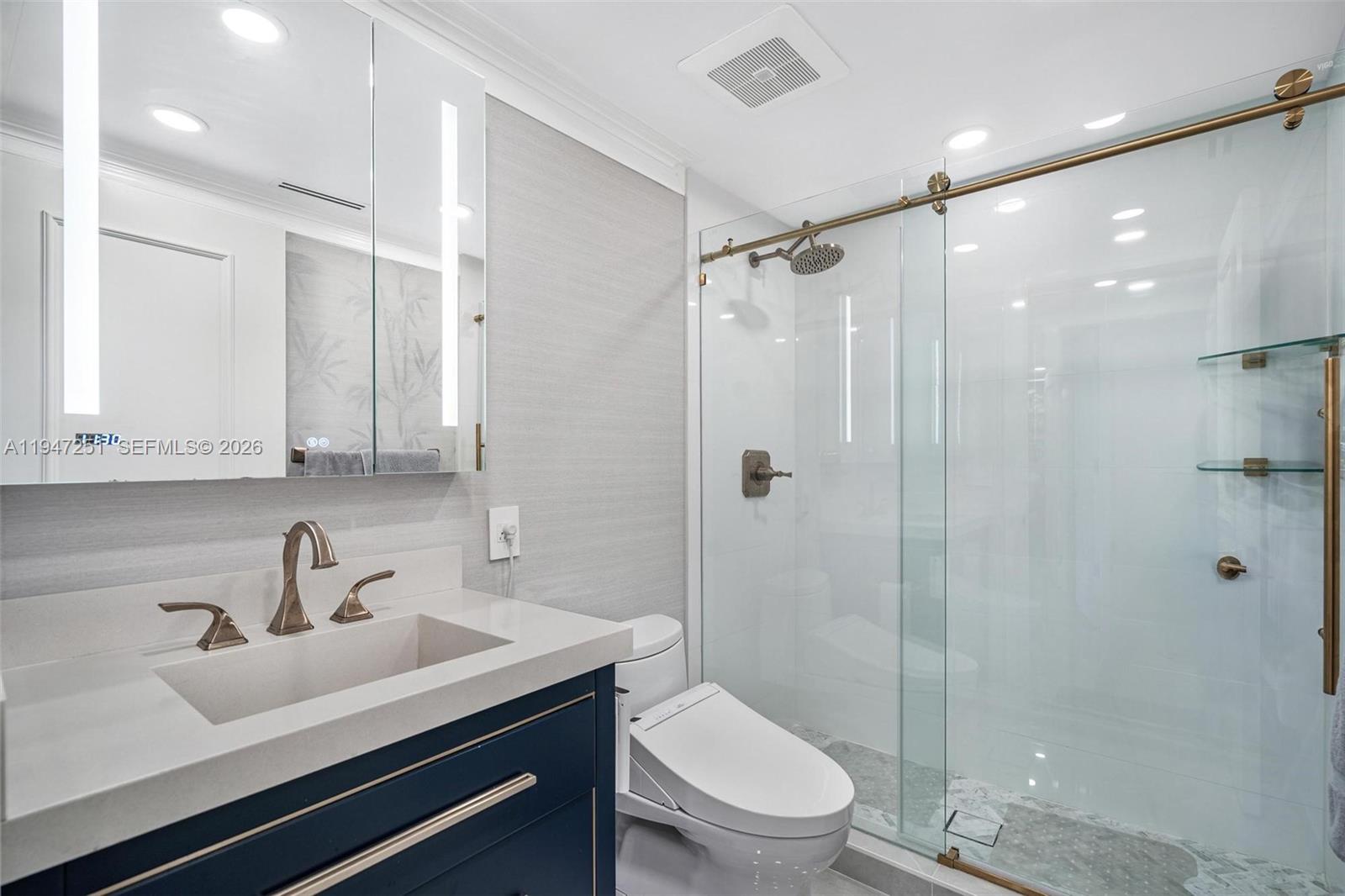 9559 Collins Avenue, Unit S4E Surfside, FL 33154 - Photo 26 of 37 a bathroom with a sink toilet a mirror and shower