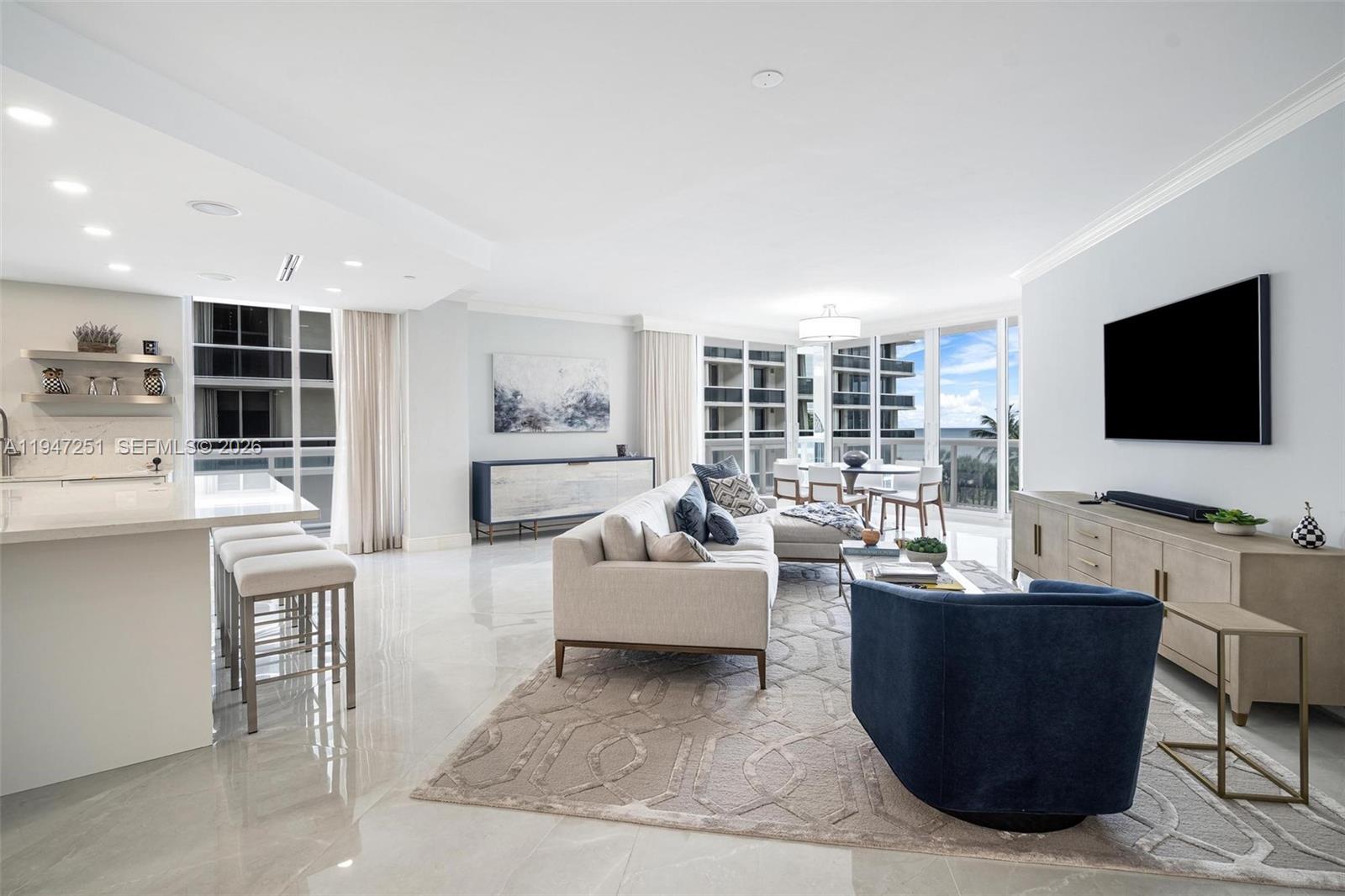 9559 Collins Avenue, Unit S4E Surfside, FL 33154 - Photo 3 of 37 a living room with furniture and a flat screen tv