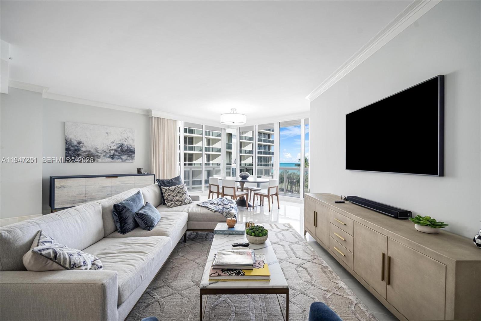 9559 Collins Avenue, Unit S4E Surfside, FL 33154 - Photo 5 of 37 a living room with furniture and a flat screen tv