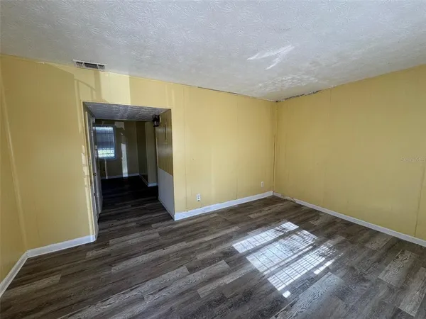 a view of a room with wooden floor and brick walls