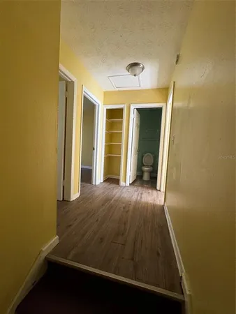 an entryway view with wooden floor and cabinet