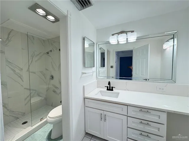 a bathroom with a toilet a sink shower and mirror