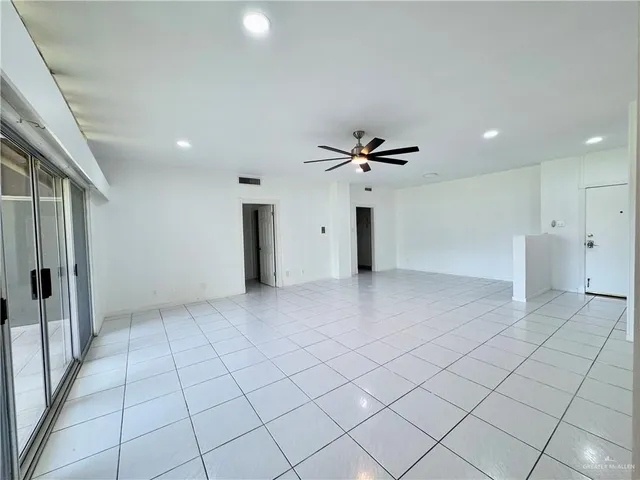 an empty room with a ceiling fan and window