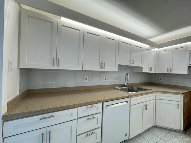 a kitchen with white cabinets and white appliances