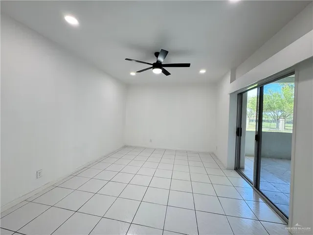 an empty room with windows and ceiling fan