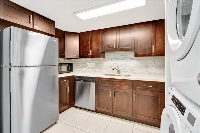 a kitchen with stainless steel appliances granite countertop a refrigerator and a sink
