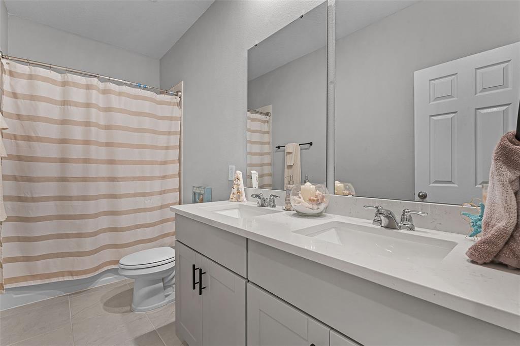 2286 Huntsman Rdg Road Minneola, FL 34715 - Photo 22 of 35 a bathroom with a sink a toilet and shower curtain