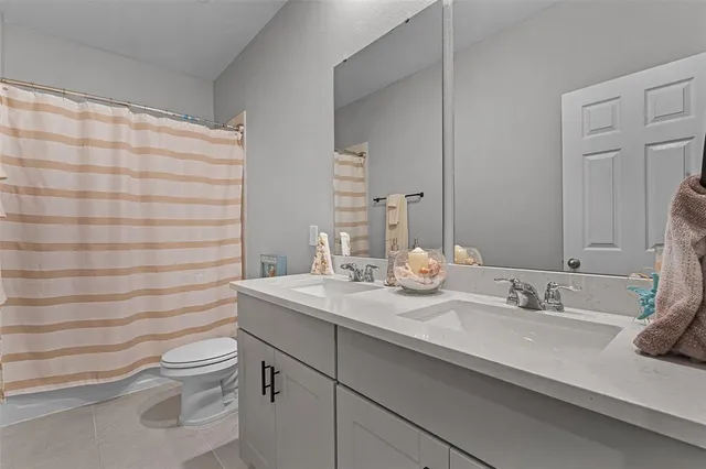 a bathroom with a granite countertop sink a toilet and a mirror