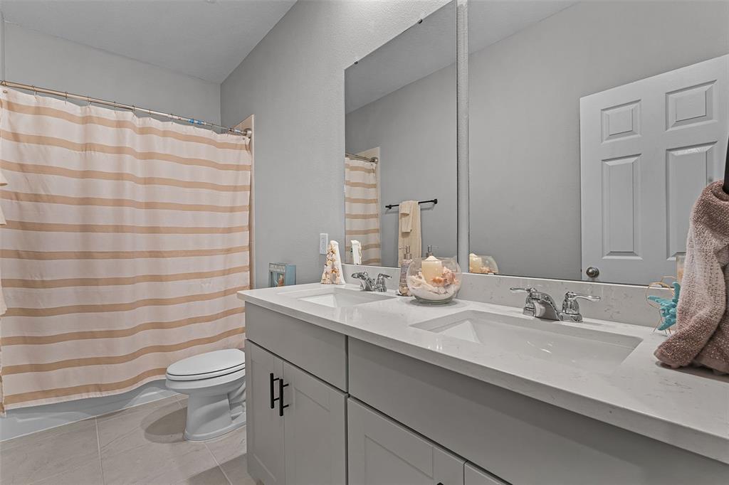 2286 Huntsman Rdg Road Minneola, FL 34715 - Photo 23 of 35 a bathroom with a granite countertop sink a toilet and a mirror