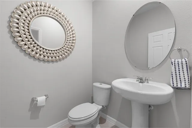 a bathroom with a sink mirror and toilet