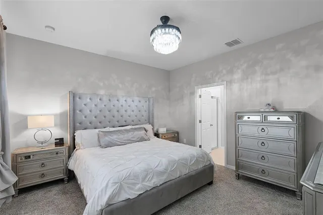 a bedroom with a bed and a chandelier