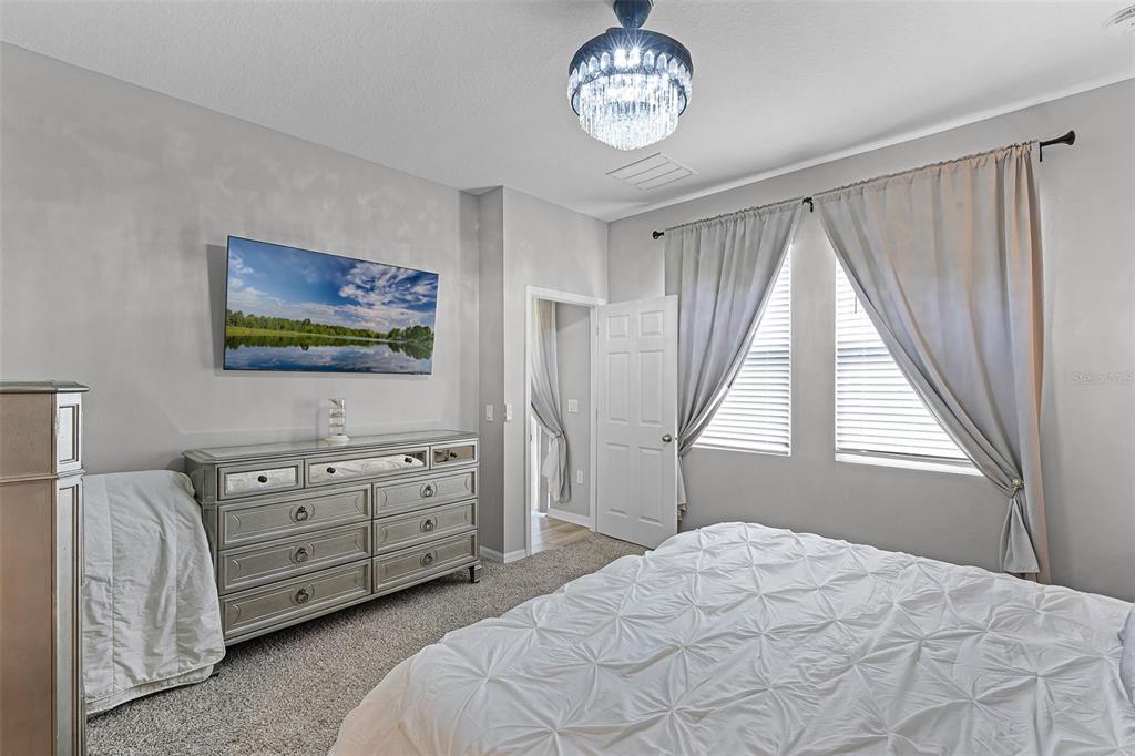 2286 Huntsman Rdg Road Minneola, FL 34715 - Photo 29 of 35 a bedroom with a bed and a chandelier