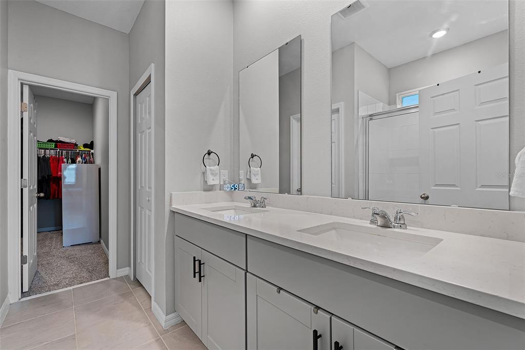 2286 Huntsman Rdg Road Minneola, FL 34715 - Photo 31 of 35 a bathroom with double sink and a mirror