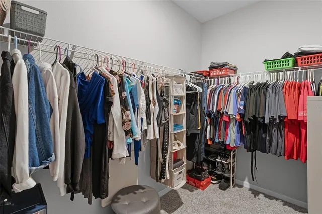 a view of walk in closet with clothes