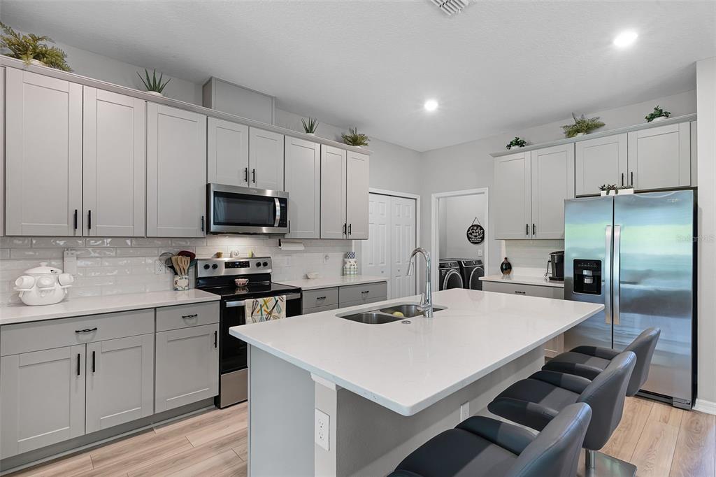 2286 Huntsman Rdg Road Minneola, FL 34715 - Photo 7 of 35 a kitchen that has a lot of white cabinets and stainless steel appliances