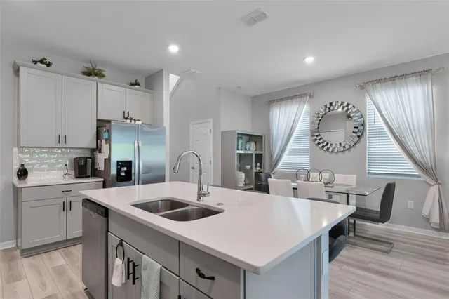 a kitchen with a table chairs sink and cabinets
