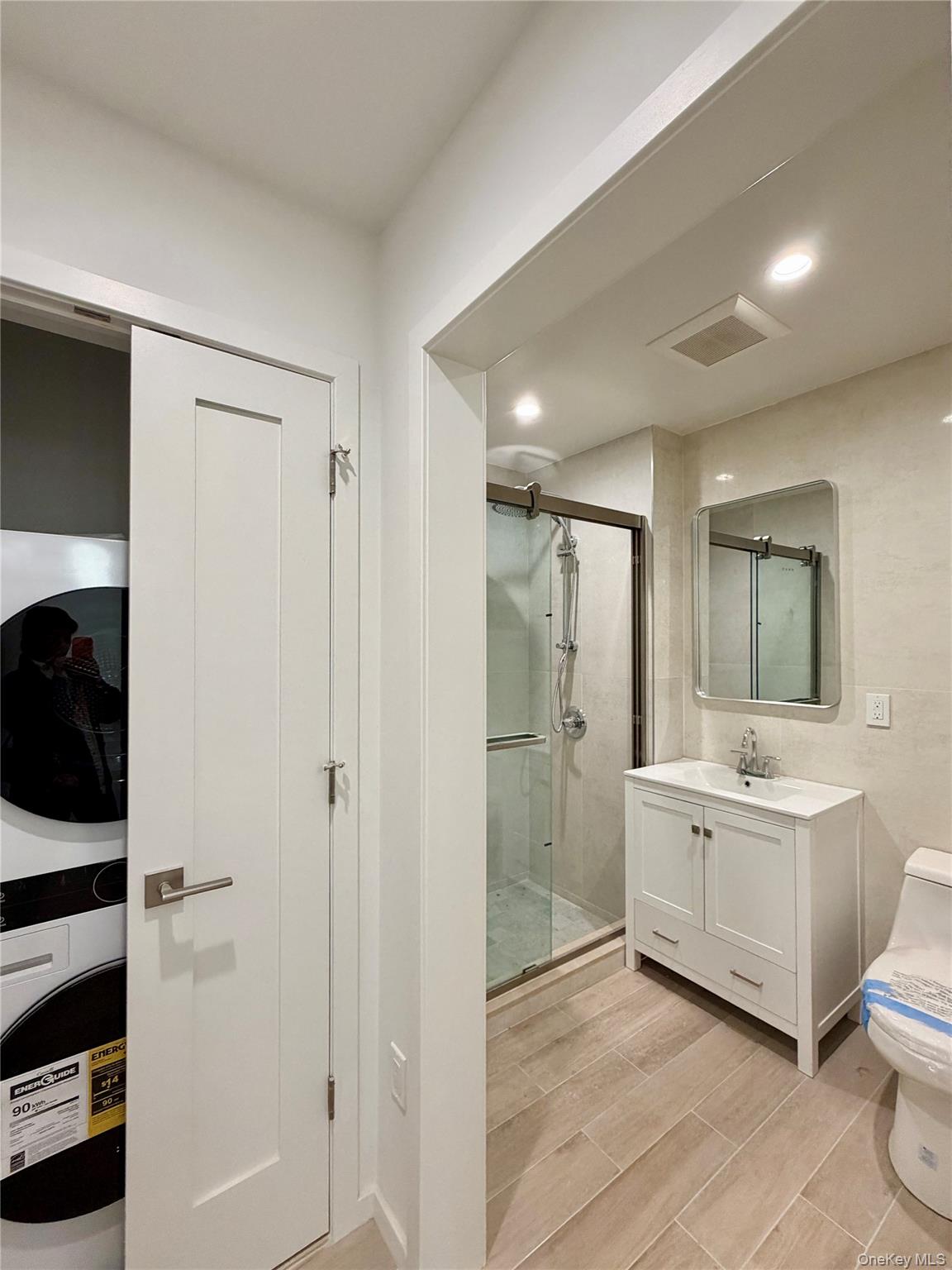 40-09 29th Street, Unit 2B Queens, NY 11101 - Photo 10 of 15 a bathroom with a double vanity sink toilet mirror and bathtub