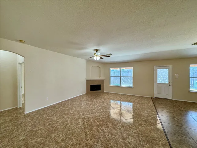 an empty room with windows and fireplace
