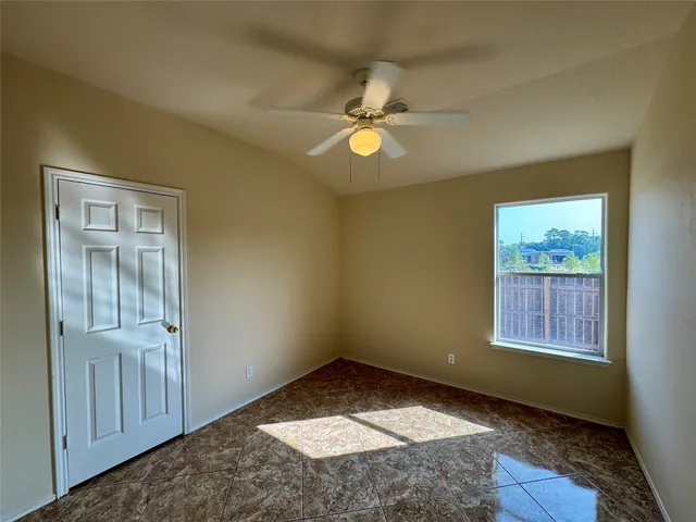 an empty room with windows and fan