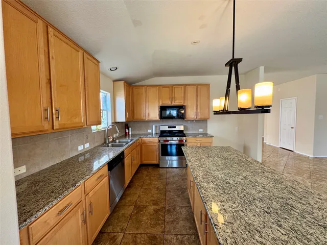 a large kitchen with kitchen island granite countertop a sink window and stainless steel appliances