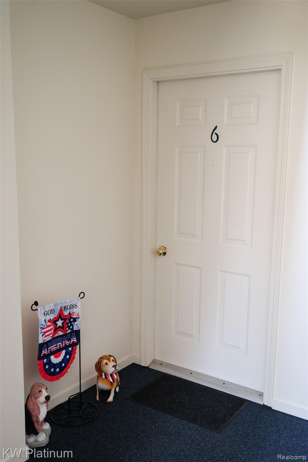 1700 River Road, Unit 6 Marysville, MI 48040 - Photo 4 of 32 White interior door with a brass-toned doorknob, featuring raised panel details and dark numbering