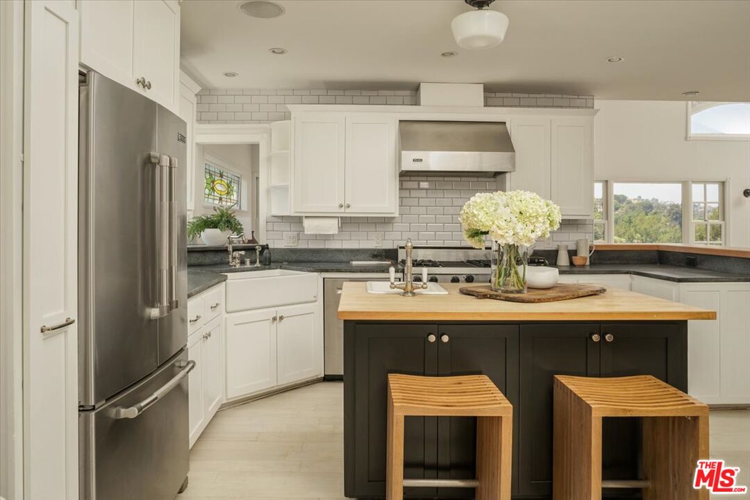 3983 Sunswept Drive Studio City, CA 91604 - Photo 17 of 53 a kitchen with kitchen island granite countertop a sink cabinets and stainless steel appliances