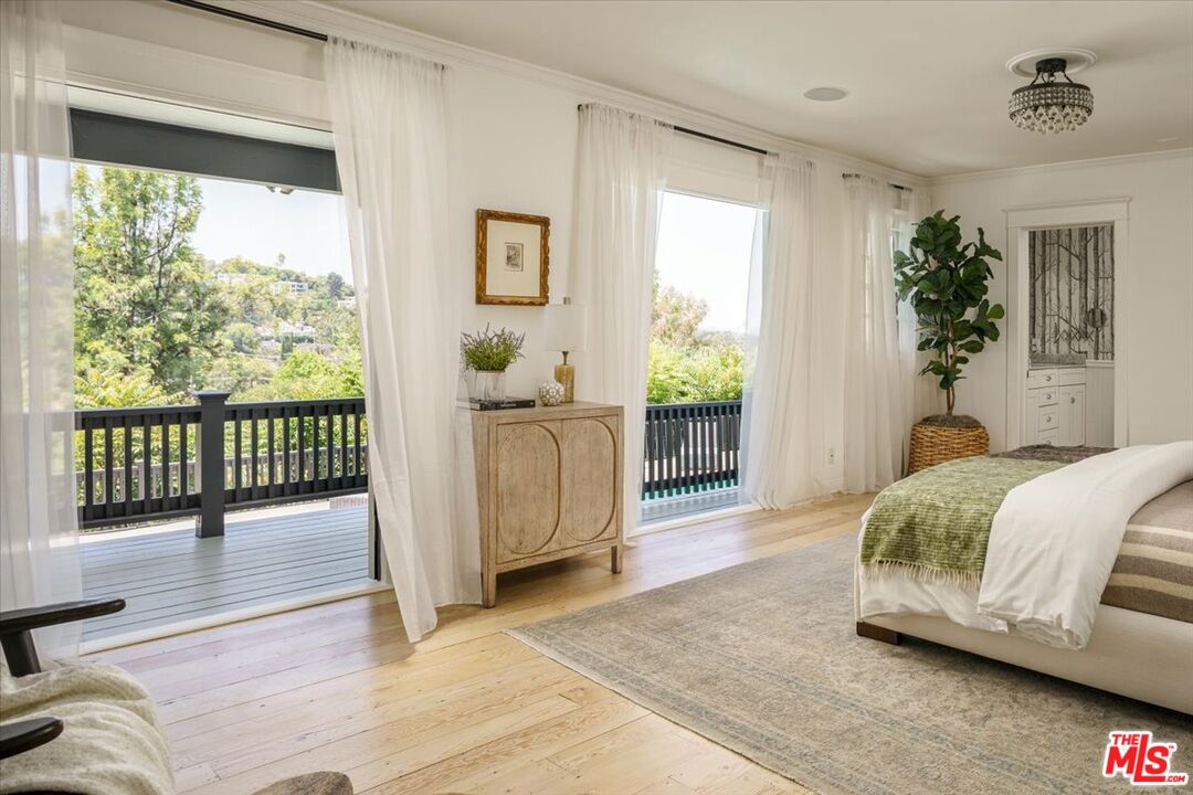 3983 Sunswept Drive Studio City, CA 91604 - Photo 32 of 53 a spacious bedroom with a balcony a bed and a wooden floor