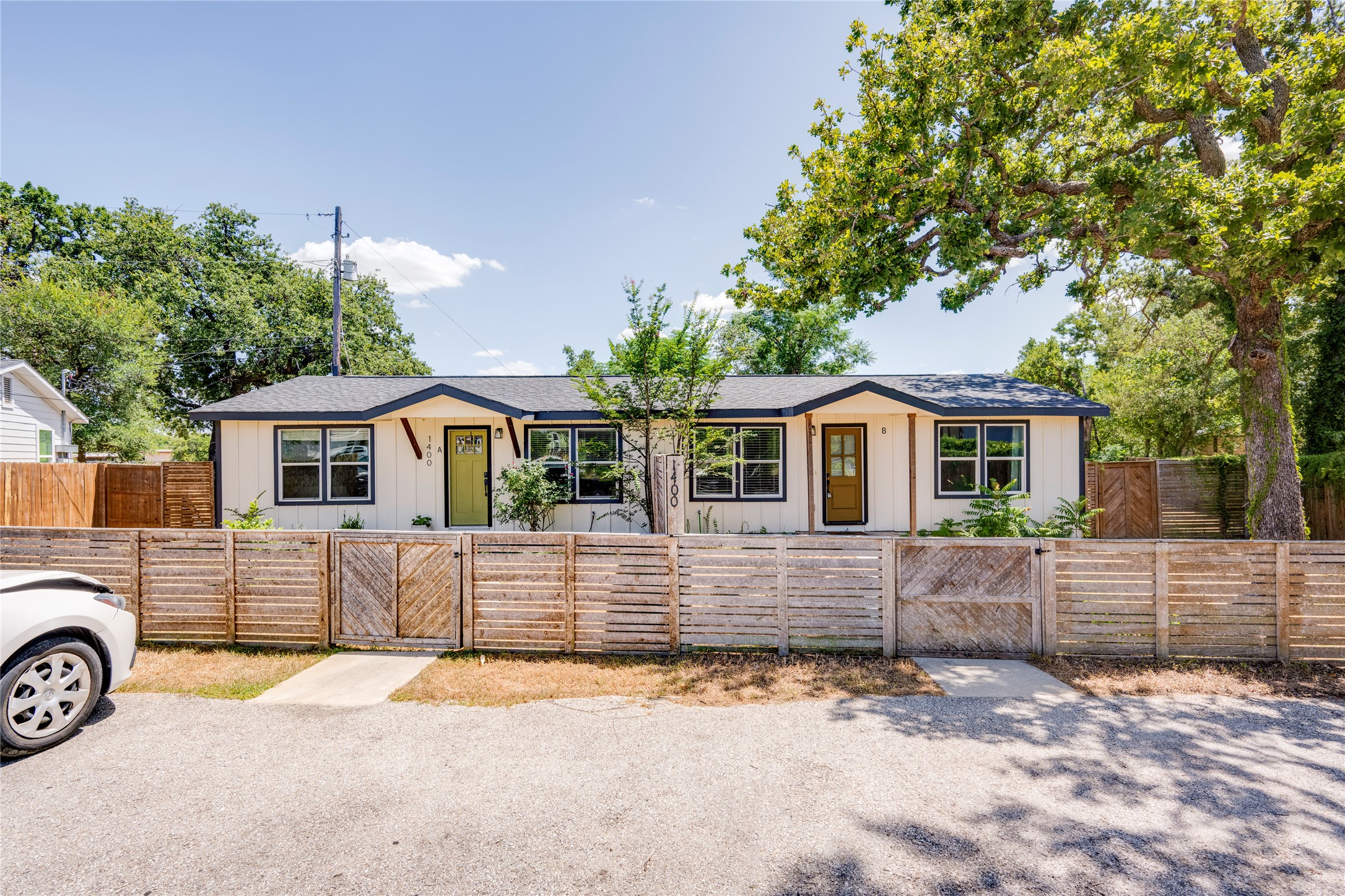 1400 Marcus Place, Unit B Austin, TX 78721 - Photo 6 of 39 A charming single-level residence behind a wooden fence, nestled amongst mature trees for natural shade.